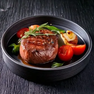 Marinade Filet Mignon cuit avec quelques tomates et herbes aromatiques